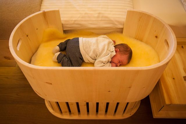 Babynest aus Zirbenholz: Offene Klappe zum Bett hingewandt © Wohnkultur Strantz / Weiss Bernd