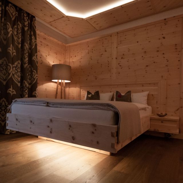 Schlafzimmer mit Holzwand, Holzboden, Holzdecke und Zirbenholz-Doppelbett © Wohnkultur Strantz / Nicole Löwy